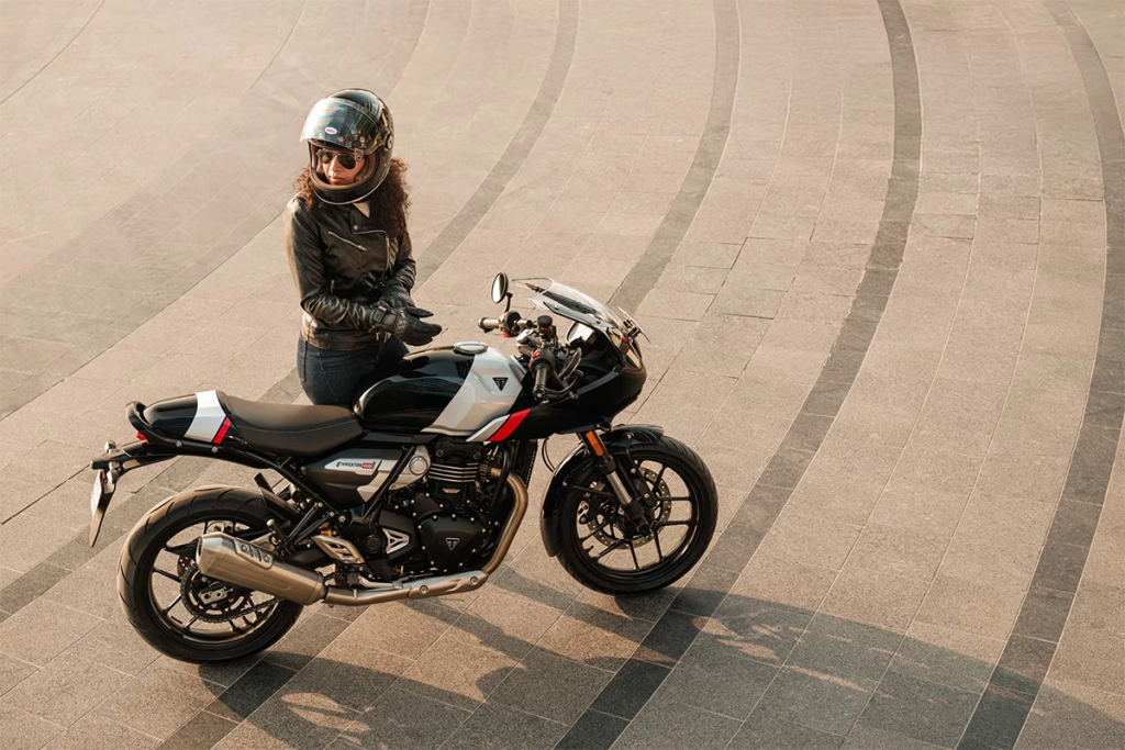 The new Triumph Thruxton 400 blends classic cafe racer styling with modern performance, featuring a semi-faired design and sporty riding stance.